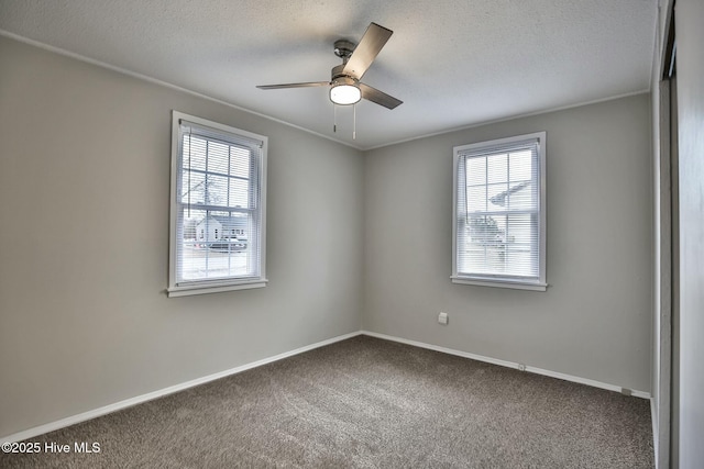 empty room with baseboards, plenty of natural light, ceiling fan, and carpet