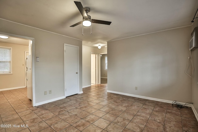 spare room featuring a ceiling fan, baseboards, and light tile patterned floors