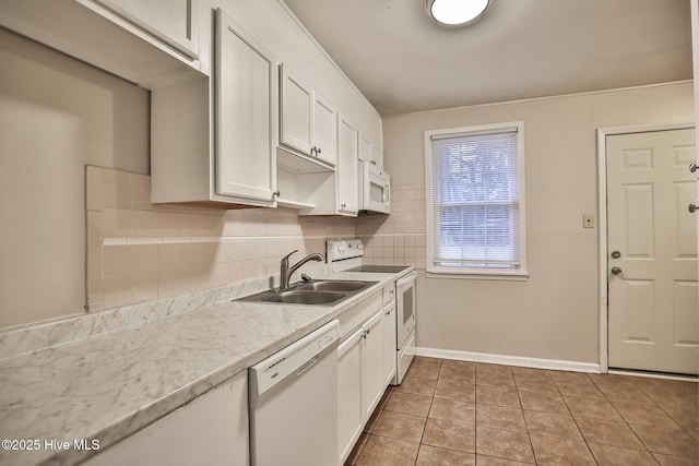 kitchen featuring tasteful backsplash, a sink, white appliances, white cabinets, and tile patterned flooring