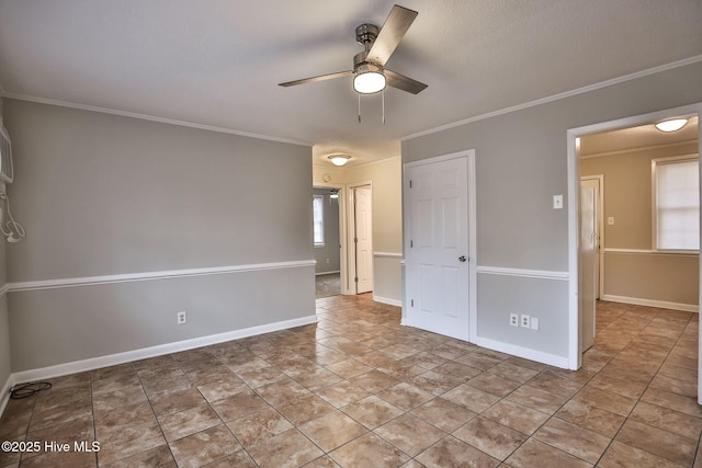 spare room featuring ornamental molding, baseboards, and ceiling fan