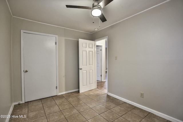 unfurnished bedroom featuring ceiling fan, baseboards, and tile patterned flooring