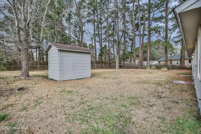 view of yard with a fenced backyard, an outbuilding, and a storage shed