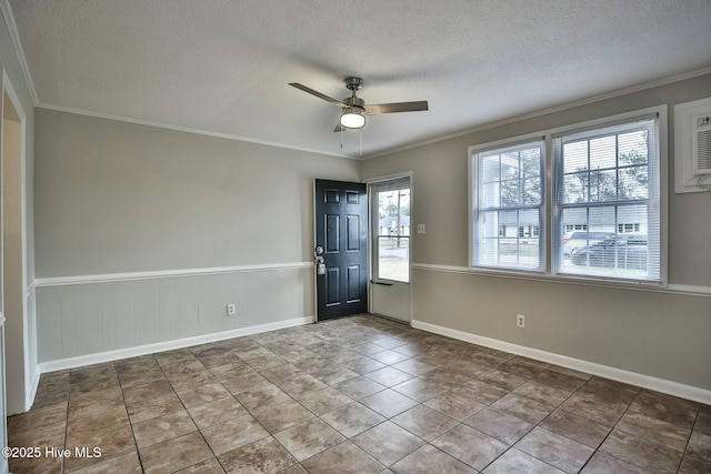 tiled empty room featuring plenty of natural light, a textured ceiling, ceiling fan, and crown molding
