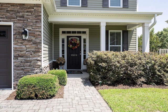 6509 Fawn Settle Dr, Wilmington, NC 28409 - view of exterior entry with stone siding and a porch