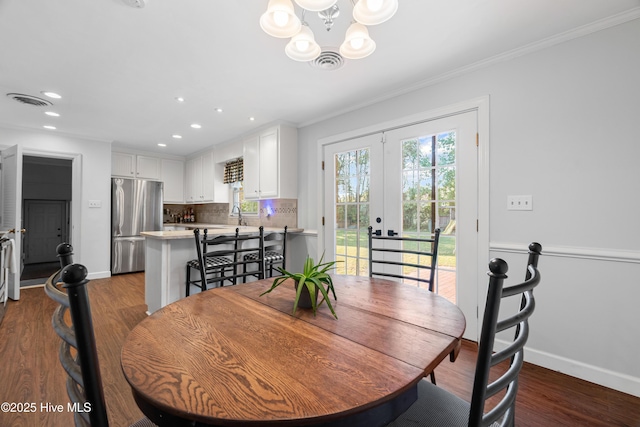 1401 W Queen St, Edenton, NC 27932 - dining room with baseboards, crown molding, french doors, and a chandelier