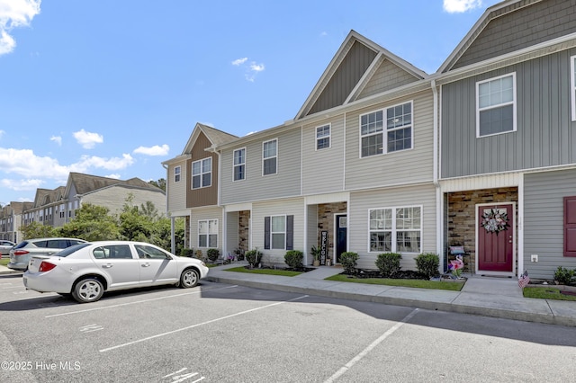 141 Beacon Woods Dr, Holly Ridge, NC 28445 - townhome / multi-family property with board and batten siding, stone siding, uncovered parking, and a residential view