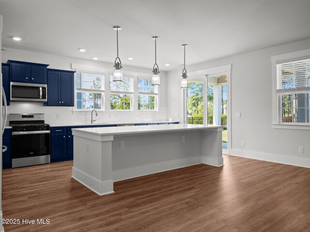 153 Ballantine Grove Ln, Newport, NC 28570 - kitchen with appliances with stainless steel finishes, blue cabinets, light countertops, decorative backsplash, and healthy amount of natural light