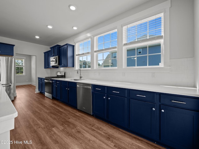 153 Ballantine Grove Ln, Newport, NC 28570 - kitchen with appliances with stainless steel finishes, blue cabinetry, backsplash, a sink, and dark wood-style flooring