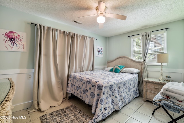 bedroom with a ceiling fan and a textured ceiling