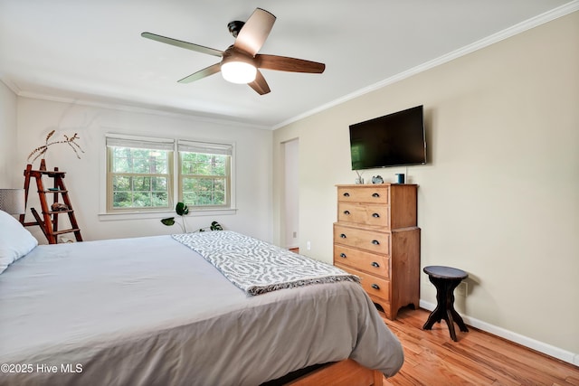 bedroom with light wood-style floors, crown molding, baseboards, and a ceiling fan