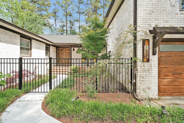 view of home's exterior with brick siding, fence, a gate, and roof with shingles