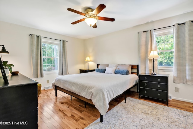 bedroom with wood finished floors, baseboards, and a ceiling fan