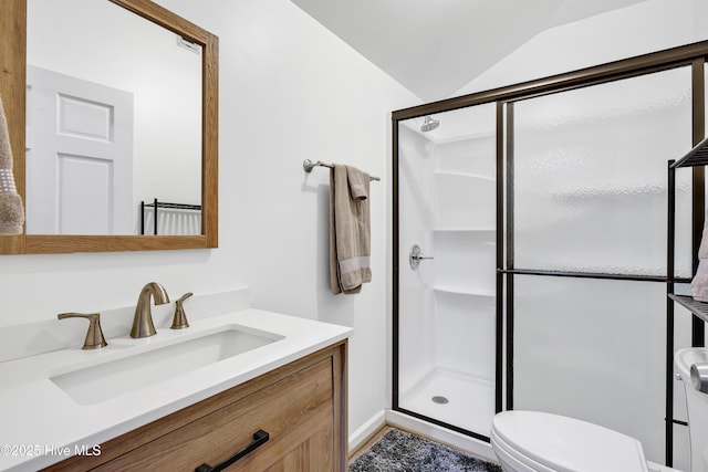 bathroom with toilet, a stall shower, lofted ceiling, and vanity