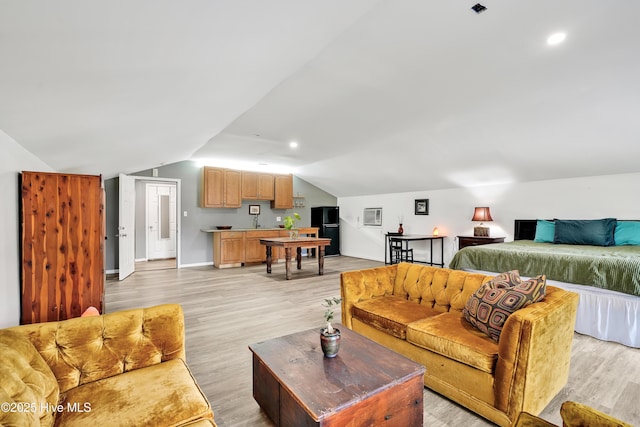living area with lofted ceiling, light wood-type flooring, and baseboards