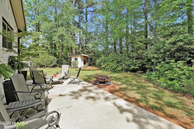 view of patio with an outdoor fire pit and an outdoor structure
