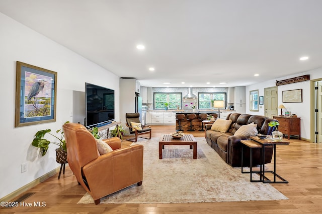 living room featuring recessed lighting, light wood-style floors, and baseboards