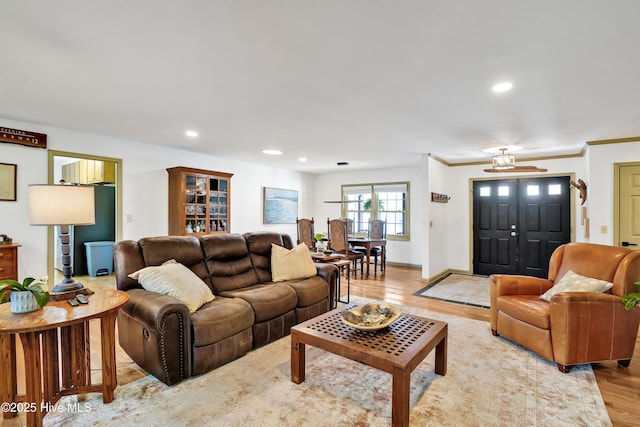 living area with wood finished floors, recessed lighting, crown molding, and baseboards