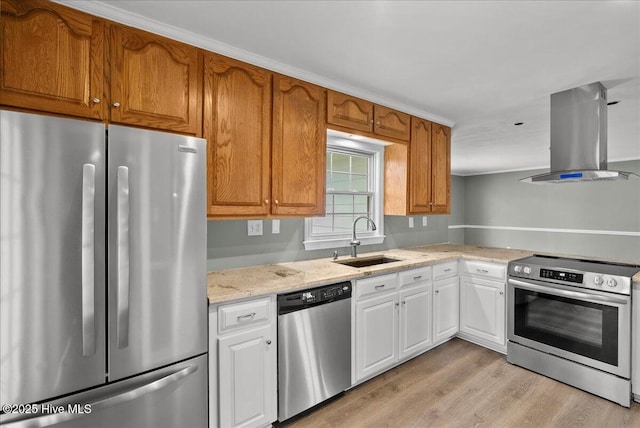 kitchen featuring light stone counters, a sink, island range hood, stainless steel appliances, and light wood-style flooring