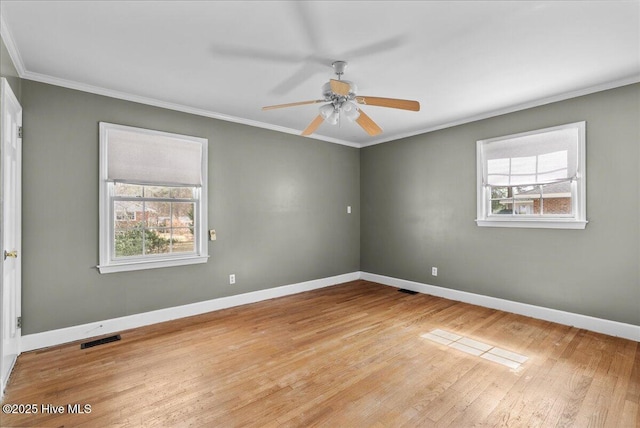 unfurnished room featuring plenty of natural light, crown molding, and baseboards