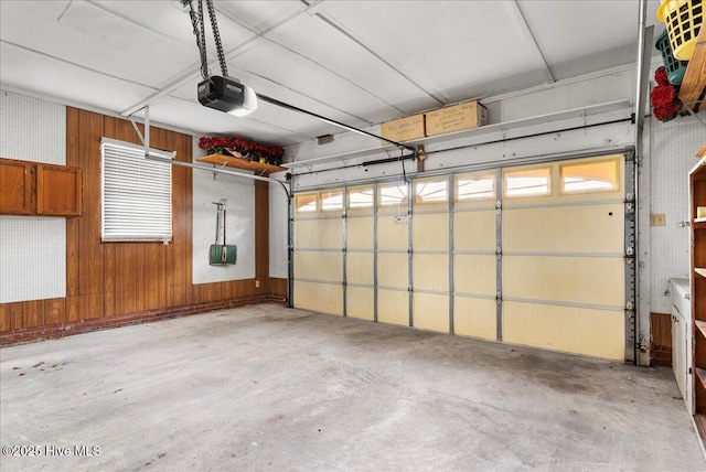 garage featuring a garage door opener and wooden walls