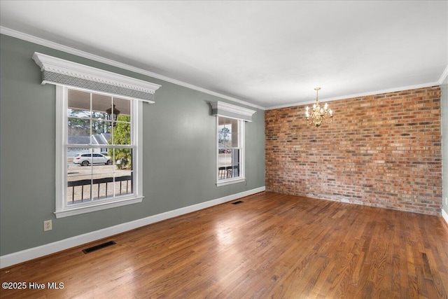 unfurnished room with brick wall, visible vents, a chandelier, and a healthy amount of sunlight