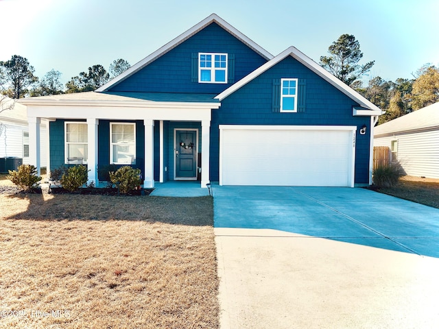 view of front of house with a front lawn, central AC, a porch, concrete driveway, and a garage
