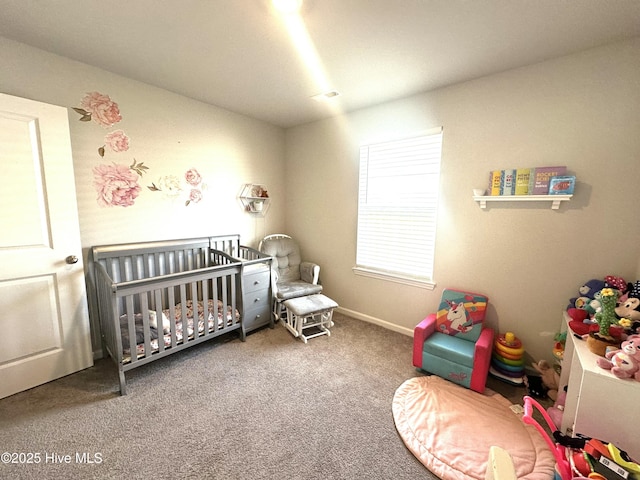 bedroom with baseboards, a crib, and carpet