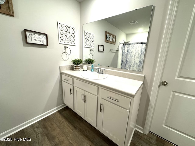full bathroom with baseboards, wood finished floors, and vanity