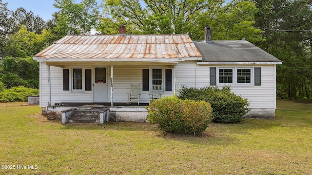 view of front of house with a chimney, a front lawn, a porch, and metal roof