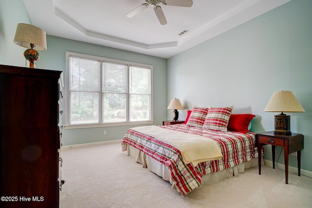 bedroom with baseboards, carpet, a raised ceiling, and ceiling fan
