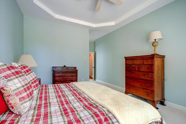 bedroom with carpet, ceiling fan, baseboards, and a raised ceiling