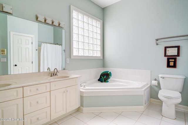 full bathroom with a garden tub, toilet, double vanity, and tile patterned flooring