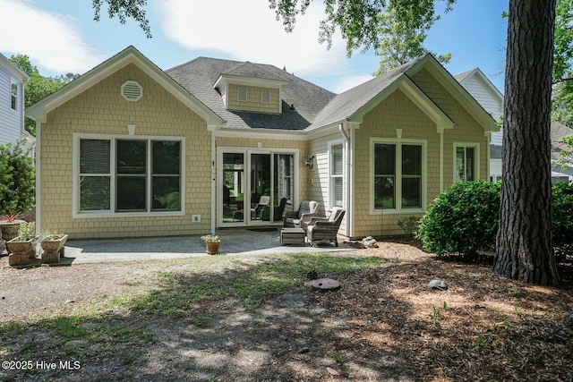 back of house with a patio area and roof with shingles