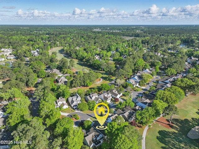 view of property location featuring a heavily wooded area and nearby suburban area