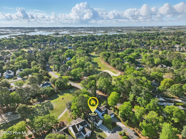 aerial view of residential area featuring a nearby body of water, a local golf course, and a tree filled landscape