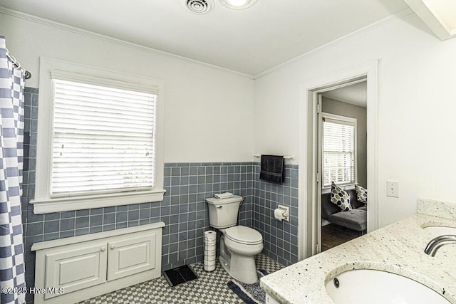 300 Moye Ave NW, Wilson, NC 27893 - full bathroom featuring double vanity, tile walls, a wainscoted wall, ornamental molding, and a shower with shower curtain