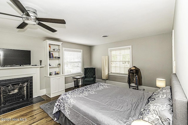 300 Moye Ave NW, Wilson, NC 27893 - bedroom featuring dark wood-style flooring, a ceiling fan, and a fireplace with flush hearth