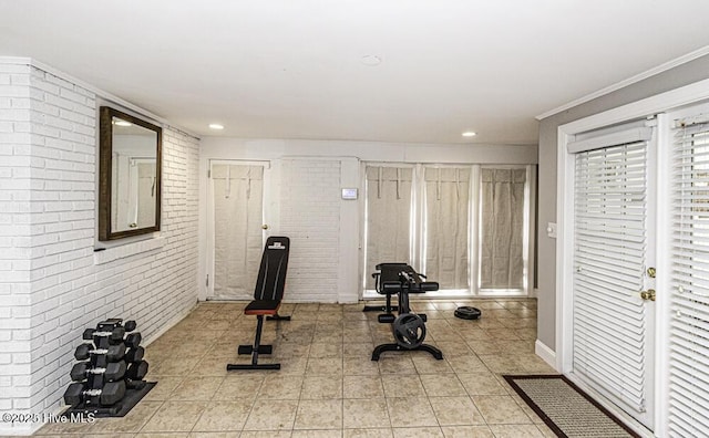 exercise room with brick wall, recessed lighting, and light tile patterned flooring