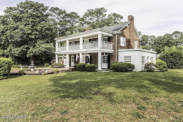300 Moye Ave NW, Wilson, NC 27893 - view of front of property featuring a balcony, a chimney, a front yard, and brick siding