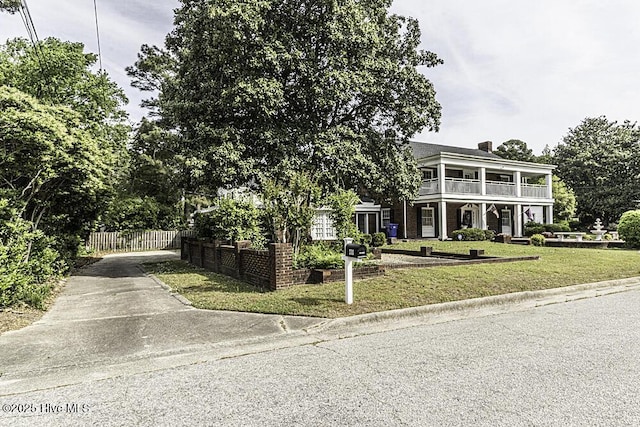 300 Moye Ave NW, Wilson, NC 27893 - greek revival house featuring a balcony, concrete driveway, and a chimney