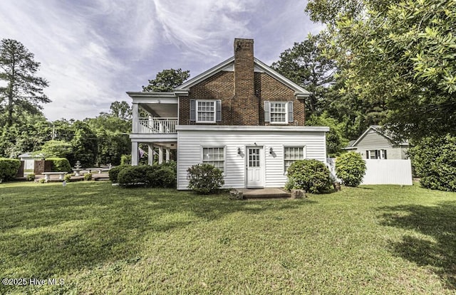 300 Moye Ave NW, Wilson, NC 27893 - back of house with a balcony, a chimney, a lawn, and brick siding