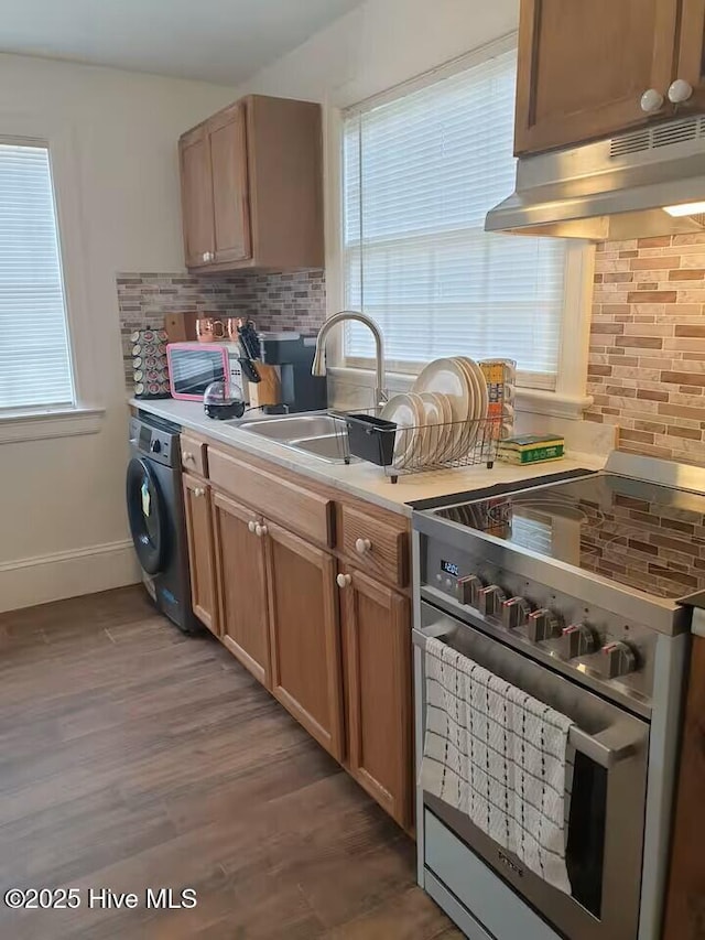 300 Moye Ave NW, Wilson, NC 27893 - kitchen featuring washer / dryer, stainless steel range, under cabinet range hood, backsplash, and light countertops
