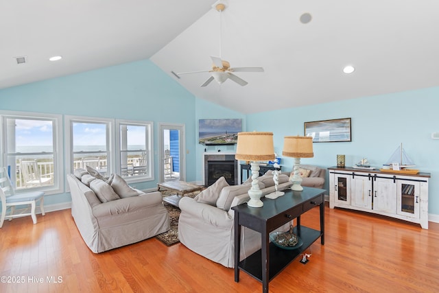 505 Caswell Beach Rd, Caswell Beach, NC 28465 - living room with a ceiling fan, a glass covered fireplace, wood finished floors, and a healthy amount of sunlight