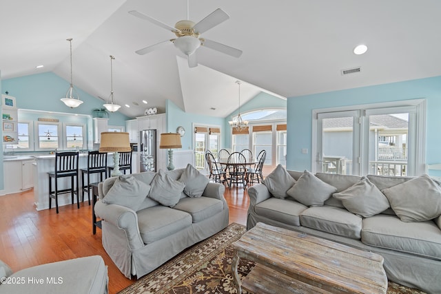 505 Caswell Beach Rd, Caswell Beach, NC 28465 - living room with light wood-style floors, vaulted ceiling, ceiling fan with notable chandelier, and visible vents