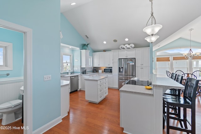 505 Caswell Beach Rd, Caswell Beach, NC 28465 - kitchen featuring a kitchen island, white cabinetry, appliances with stainless steel finishes, and a wealth of natural light