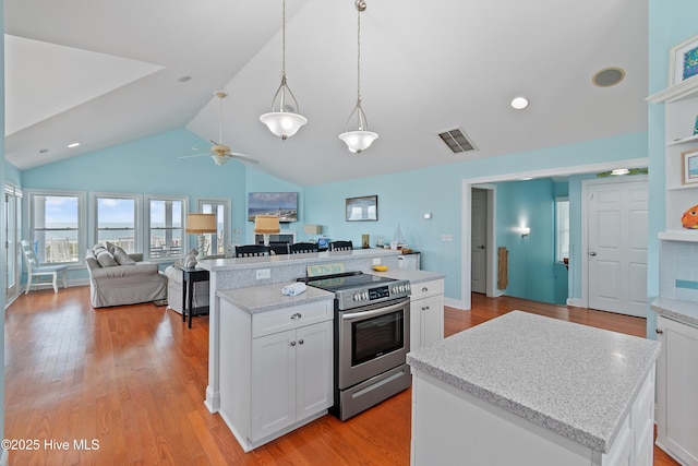 505 Caswell Beach Rd, Caswell Beach, NC 28465 - kitchen featuring open floor plan, visible vents, stainless steel range with electric stovetop, and a center island