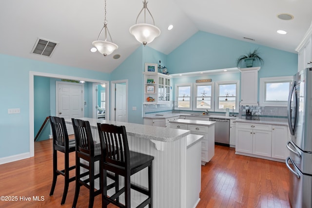 505 Caswell Beach Rd, Caswell Beach, NC 28465 - kitchen featuring appliances with stainless steel finishes, a sink, a center island, a kitchen bar, and visible vents