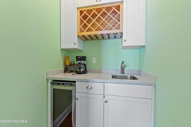 505 Caswell Beach Rd, Caswell Beach, NC 28465 - kitchen with a sink, light countertops, white cabinetry, and wine cooler