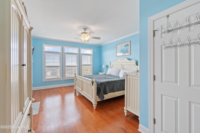 505 Caswell Beach Rd, Caswell Beach, NC 28465 - bedroom with baseboards, ornamental molding, wood-type flooring, and ceiling fan