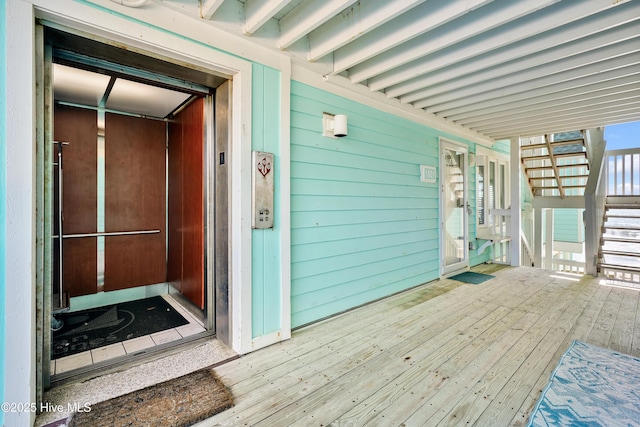 property entrance featuring elevator and a wooden deck